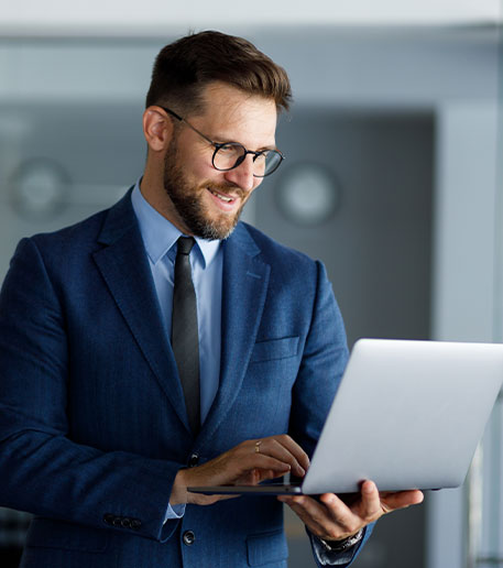 Ein Gesch&auml;ftsmann arbeitet konzentriert am Laptop in einem modernen B&uuml;ro und steht f&uuml;r Digitalisierung und Ver&auml;nderungsprozesse.